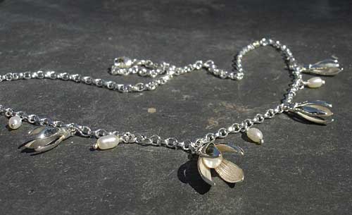 A necklace consisting of a silver chain fashioned with snowdrops