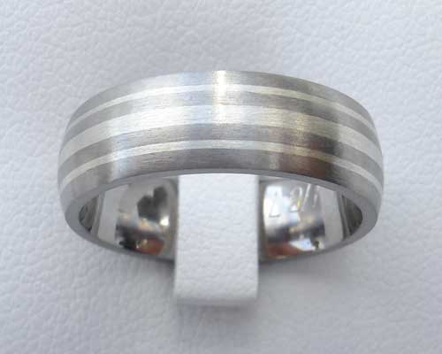 Titanium wedding ring with white gold inlays